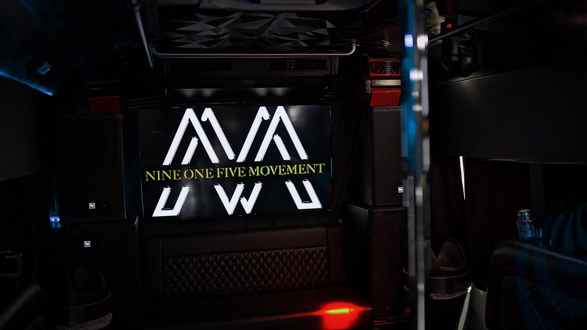 Panel iluminado con el logo de Nine One Five Movement dentro del bus